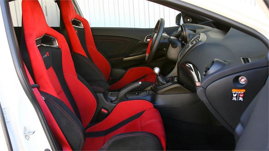 Los asientos deportivos son de tipo bacquet -tapizados en rojo y negro con dobles costuras en rojo- y van situados 2 centímetros más bajos. 