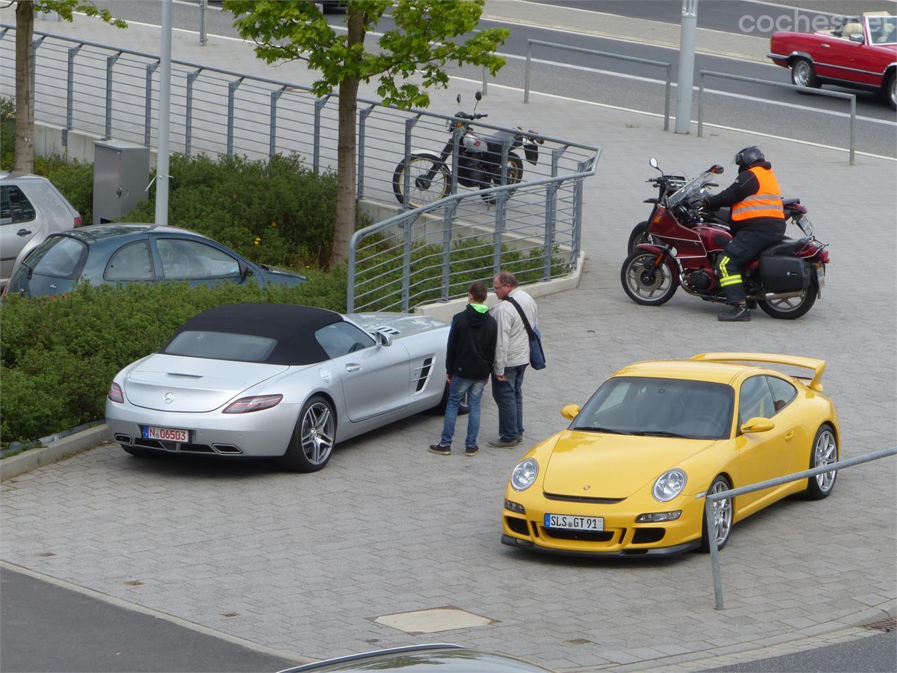 En la puerta del hotel un Mercedes-Benz SLS AMG y un Porsche 911 GT3 aparcados en la acera.