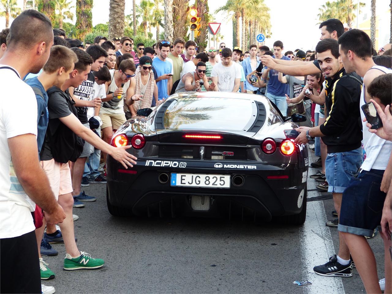 Un Ferrari F430 Scudería intentando abrirse paso entre la multitud.