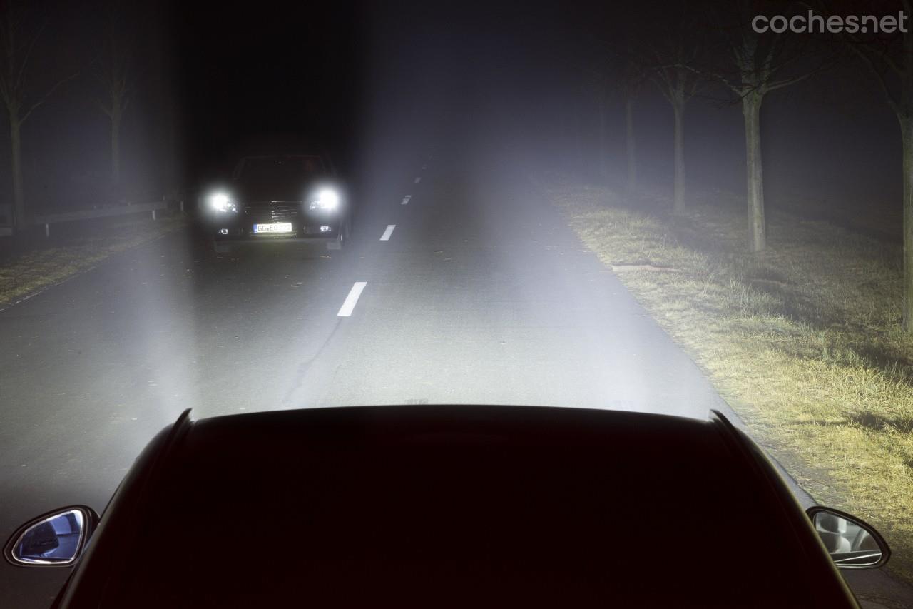 Primer de la linterna del coche en noche. las luces delanteras del  deportivo azul. la luz del coche.